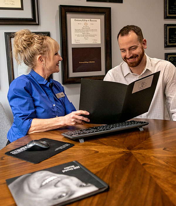 Hill Dental Studio employee going over paperwork with patient