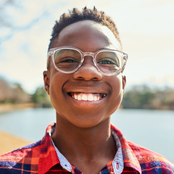 young boy wearing glasses and smiling