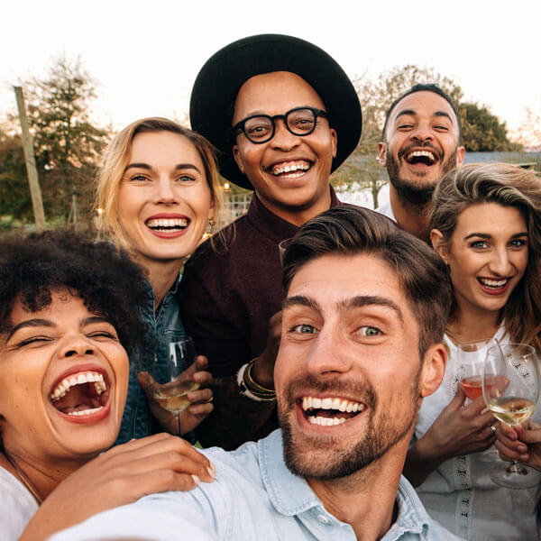 group of friends taking a selfie, smiling and laughing